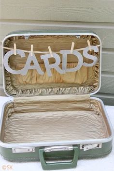 an open suitcase sitting on top of a table next to a sign that says cards