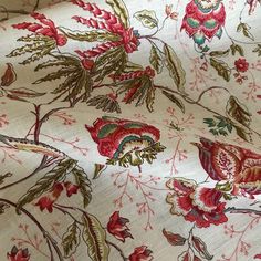 the fabric has red flowers and leaves on it