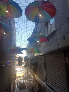 an alleyway with umbrellas hanging from the ceiling