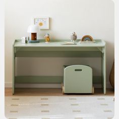 a green desk with a white lamp and some toys on the table next to it