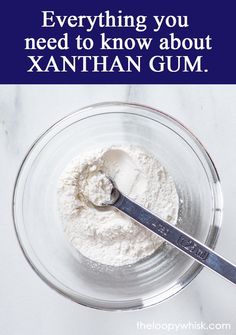 a bowl filled with white powder and a spoon in it that says everything you need to know about xanthan gum