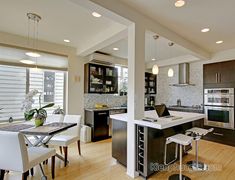 a modern kitchen with stainless steel appliances and wood flooring is pictured in this image