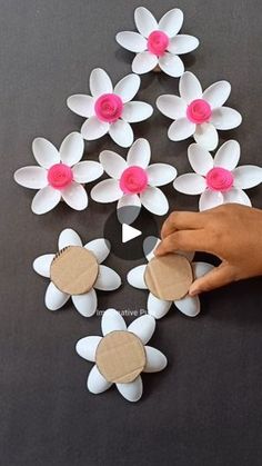 someone is making paper flowers out of toilet paper and cardboard circles on the table with their hands