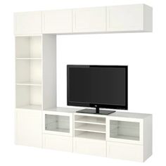 a flat screen tv sitting on top of a white entertainment center next to a book shelf