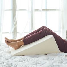 a woman laying on top of a white mattress