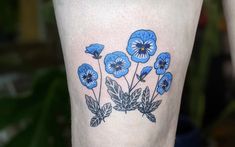 a blue flower tattoo on the leg