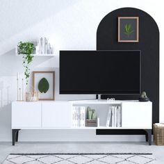 a white entertainment center with black and white accents in a living room, including a large television