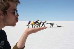 a man is holding out his fingers in front of a group of people on the desert