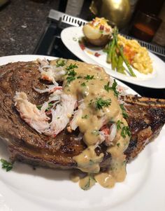 two white plates with food on them sitting on a table