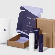 the contents of a skin care gift set including an open box, cream tube and lotion