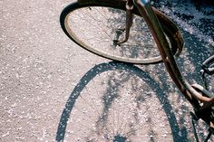 the shadow of a bicycle on the ground with it's front wheel leaning up