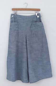 a blue skirt hanging on a wooden hanger