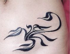 a woman's stomach with an artistic tattoo design on her lower back and side