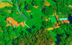 an aerial view of a tennis court in the middle of a wooded area with trees