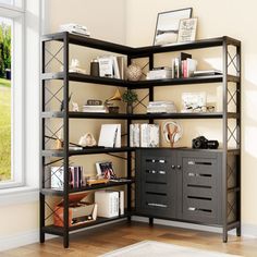 a book shelf with many books on top of it in front of a large window