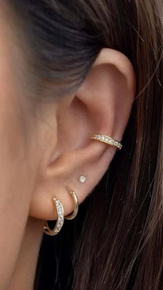 a woman wearing gold ear piercings with diamonds