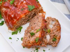 meatloaf with marinara sauce and onions on a white plate