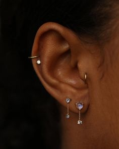 a close up of a person's ear with three different piercings on it