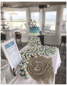 a table topped with cupcakes covered in frosting next to a cake on top of a plate