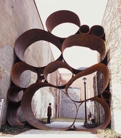 a large metal sculpture sitting on the side of a building