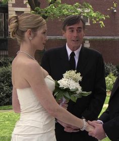 a bride and groom holding hands during their wedding ceremony