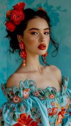 a woman in a blue dress with red flowers on her head, wearing large earrings