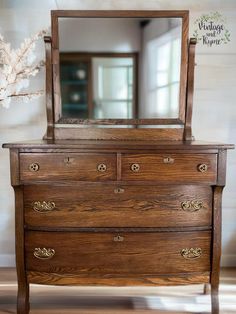 a wooden dresser with a mirror on top of it