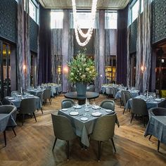 a dining room with tables and chairs set up for an event or function in front of large windows