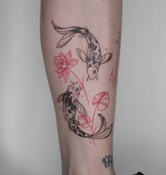 a woman's leg with two koi fish and lily flowers tattoo on it