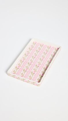 a pink and white flowered cloth on a white surface