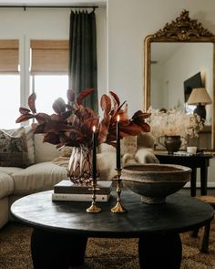 a living room filled with furniture and a large mirror on the wall above it's coffee table