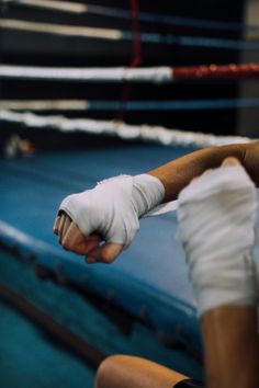 a man in white gloves standing next to a boxing ring