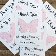 pink and white butterfly baby shower thank you cards with matching envelopes on a wooden table