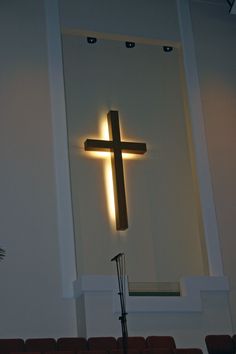 a cross is lit up in the corner of a room