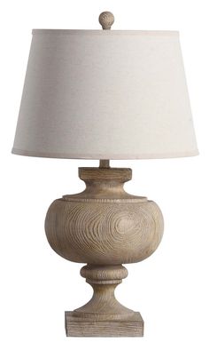 a lamp with a white shade on top of it and a wooden base around the light