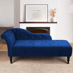 a blue chaise lounge sitting on top of a rug in front of a fireplace