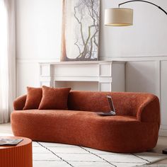 a living room with a couch, table and lamp on the floor in front of it