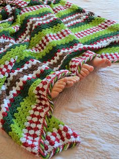 a crocheted blanket laying on top of a bed