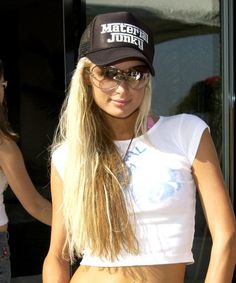 a woman with long blonde hair wearing sunglasses and a hat