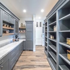 a kitchen with gray cabinets and white counter tops