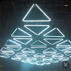 the ceiling is lit up with white lights and geometric shapes on it's sides