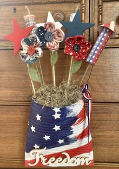 an american flag vase filled with flowers and pins