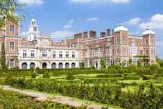 an ornate building with hedges in the foreground