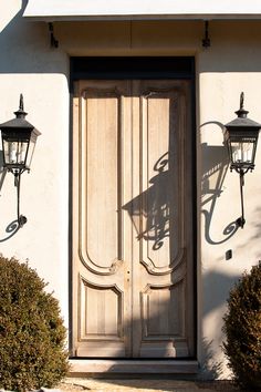 the front door of a house with two lamps on each side