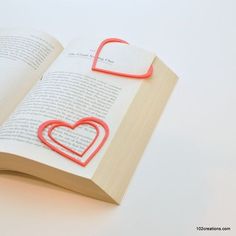 an open book with two hearts on it