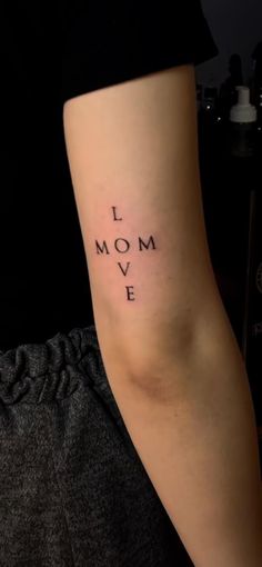 a woman with a tattoo on her arm that says i love mom ive in cursive writing