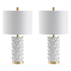 a pair of white lamps with gold accents