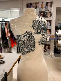 a white mannequin with black lace on it's back in a clothing store