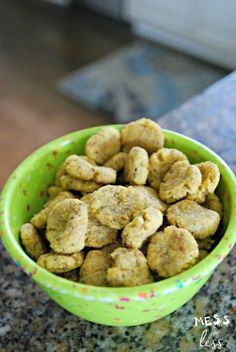 a green bowl filled with dog food on top of a counter