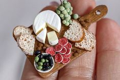 a miniature food tray with bread, grapes, cheese and crackers